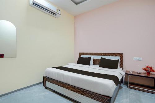 a bedroom with a bed in a white room at HOTEL O STAR INN in Raipur