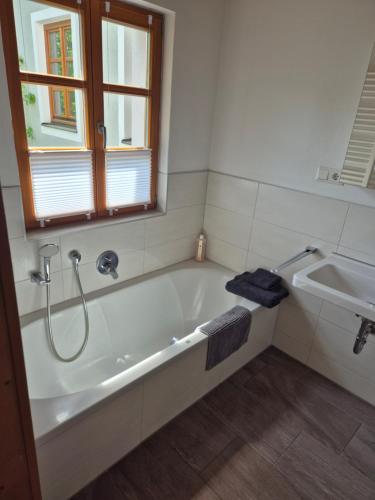 a bathroom with a bath tub and a sink at LIV Retreat in Dietenhofen