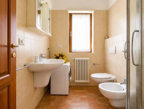 a bathroom with two sinks and a toilet and a window at Apartment Alex 2 in Domaso in Domaso