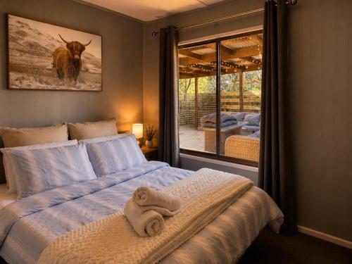 a bedroom with a bed with towels on it at The Cove - Lake Eildon in Piries