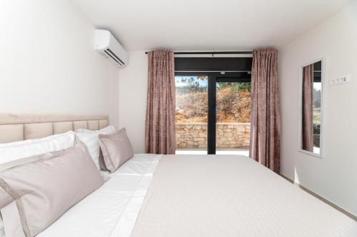 a bedroom with a white bed and a window at Villa Andrea in Splitska