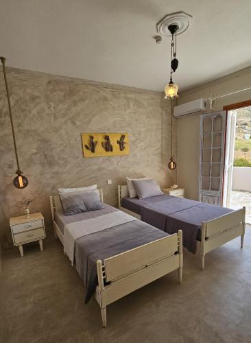 a bedroom with two beds and a wall at Zephyrus Sunset House. Amazing View and Privacy! in Agkidia