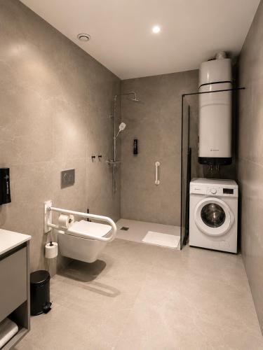 a bathroom with a shower and a washing machine at OMO STAYS Pinada Park in Guardamar del Segura