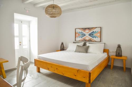a white bedroom with a bed and a table at Kastro View Apartment in Plaka Milou
