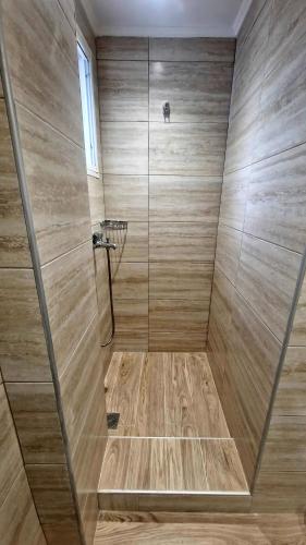 a bathroom with a shower with a wooden floor at Aelia House Kefalos - Cozy & Quiet in Kos
