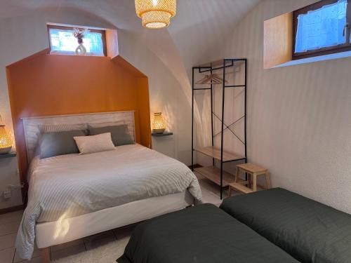 a bedroom with two beds and a window at Le Secret d'Adèle in Chateauroux-les-Alpes