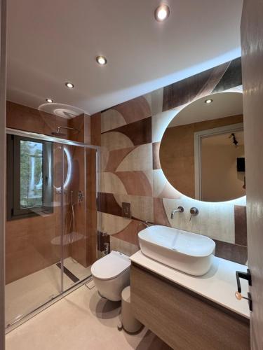 a bathroom with a toilet and a sink and a shower at Almondo Suites in Amigdhaleón