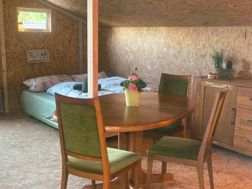 a dining room table with chairs and a bed at Cozy Cow Farm Lodge in Lucerne