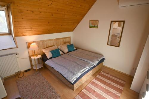 a bedroom with a bed with blue pillows at Penzión Belvia in Nová Lesná