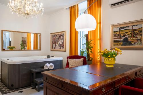 a bathroom with a tub and a table and a mirror at Relais La Lanterne in Cagliari