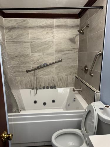 a bathroom with a bath tub and a toilet at Studio with jacuzzi near Atlantic ocean in Myrtle Beach