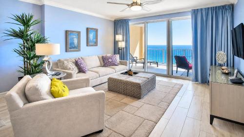 a living room with a couch and a tv and ocean views at Luxury Vacation Escape Free Beach Service Come Relax Book Now! in Panama City Beach