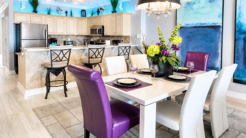 a kitchen and dining room with a table and purple chairs at Luxury Vacation Escape Free Beach Service Come Relax Book Now! in Panama City Beach