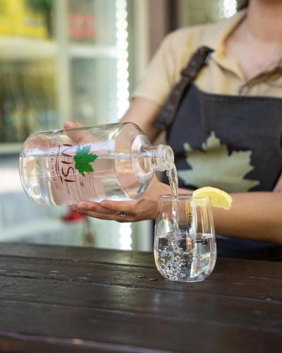 a person pouring a drink into a glass at Nisi Glamping in Paralia Rachon