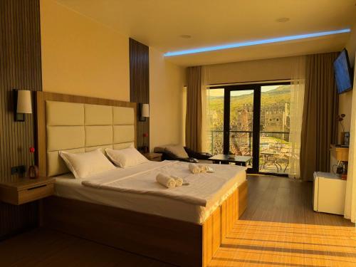 a bedroom with a large bed with a large window at Hotel DIAMOND - სასტუმრო დაიმონდ in Akhaltsikhe