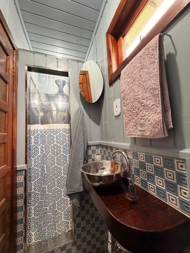 a bathroom with a sink and a shower at Pousada Nó de Pinho - Kitnet Microcasa in São Joaquim