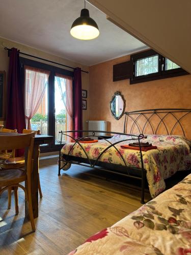 a bedroom with a bed and a table and chairs at B&B Borgo dei Cedri in Pontecchio