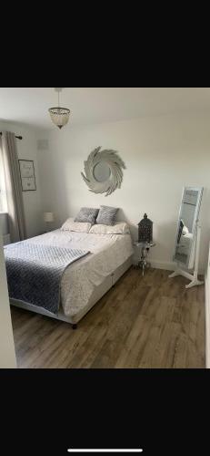 a bedroom with a bed with a painting on the wall at Glenmore in Doonbeg