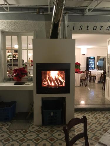 a fireplace with a fire in the middle of a room at Hotel Garden Bocca di Magra in Bocca di Magra