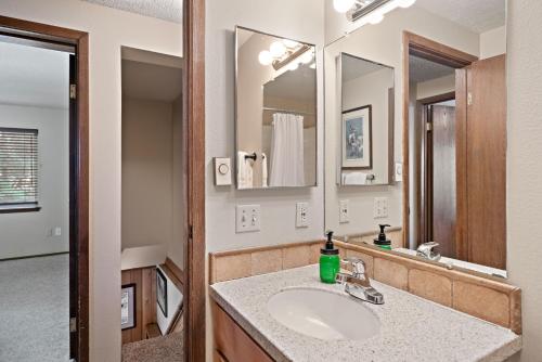 a bathroom with a sink and a mirror at Trapper 8: Cozy 4-Bedroom Condo, 1 Minute to Yellowstone, perfect for 8 guests. in Levokumskoye