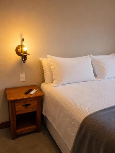 a bedroom with a bed and a nightstand next to a bed at Pouso Alvorada in Tiradentes