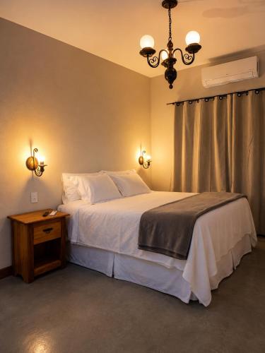 a bedroom with a large white bed and a chandelier at Pouso Alvorada in Tiradentes