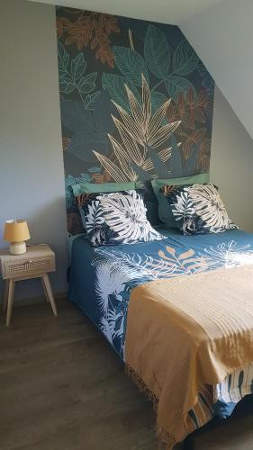 a bedroom with a bed with a floral wall at Floralie parking privé navette vers Aéroport ou Gare Beauvais in Saint-Paul
