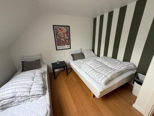 two twin beds in a room with striped walls at Kystvejen 40F in Hadsund