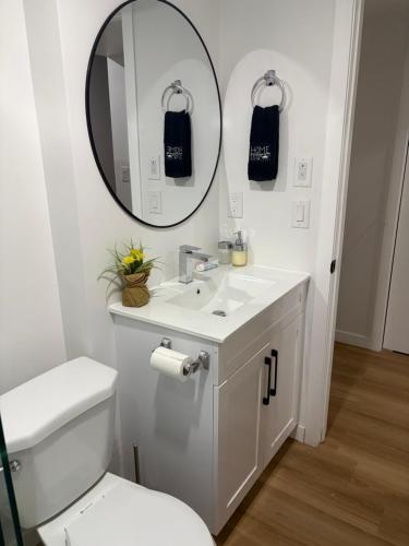 a white bathroom with a sink and a mirror at Royal Oak - 2 bedroom suite plus in-suite kitchen and laundry in Winnipeg