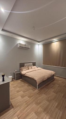 a bedroom with a large bed and a wooden floor at شاليه لافندر ينبع in Yanbu Al Bahr