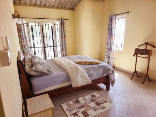 a bedroom with a bed and a window at Jugroop Beach House in Baie du Tombeau