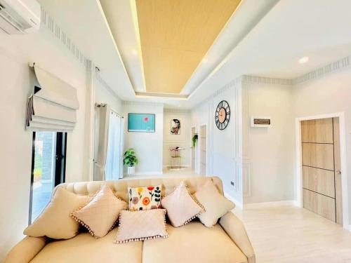 a living room with a couch with pillows at บ้านแสนสุข Hun Hin in Hua Hin