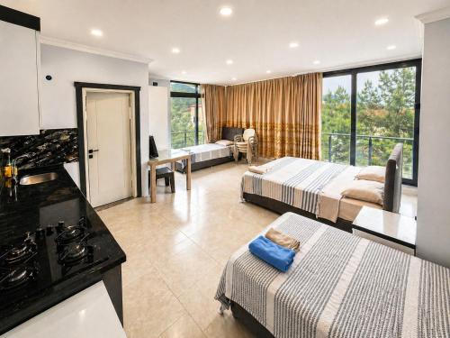 a hotel room with two beds and a kitchen at Taşhan Apart Otel in Didim