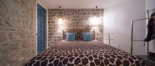 a bedroom with a large bed with a stone wall at Villa Jatica in Zaostrog