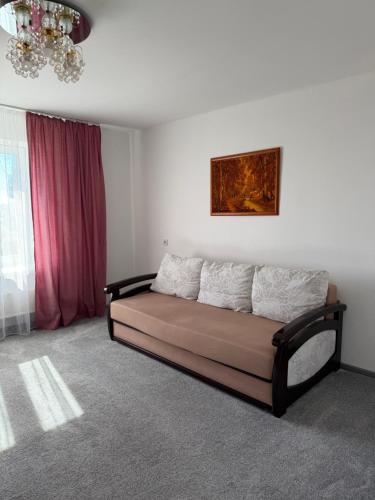 a bed in a room with a pink curtain at NV Apartments in Volodymyr-Volynskyi
