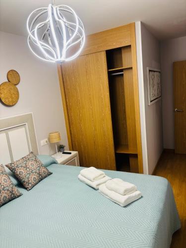 a bedroom with a bed with two towels on it at Maresia in Burela de Cabo