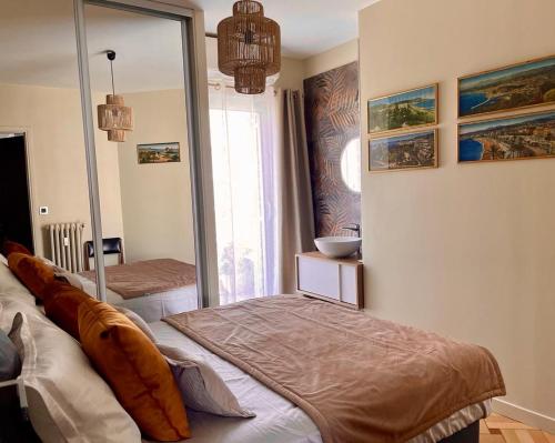 a bedroom with a bed and a large mirror at Un balcon sur la mer in Nice