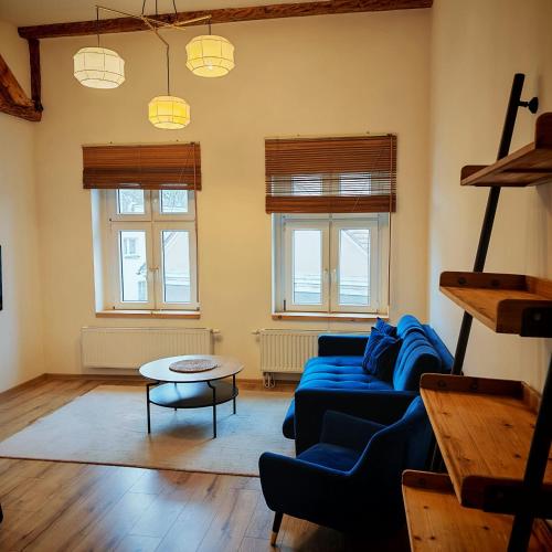 a living room with a blue couch and a table at Bramkowa 5 in Skorka