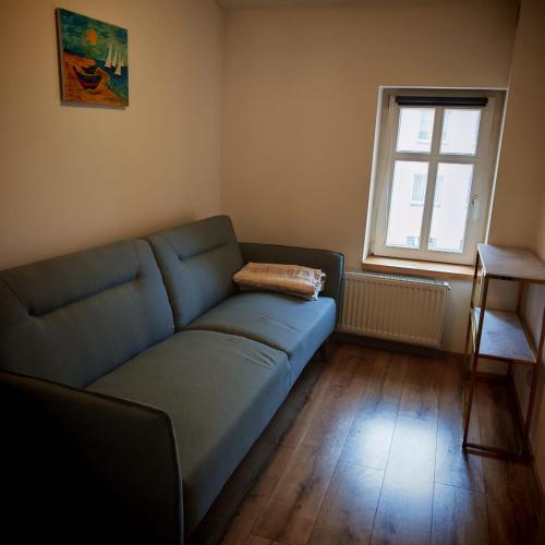 a living room with a blue couch and a window at Bramkowa 5 in Skorka