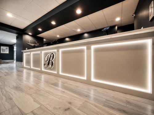 a lobby with a white wall with a sign on it at Bolero Resort in Wildwood