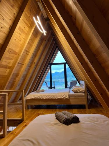 two beds in a room with a large window at LakeSideCottage in Plav