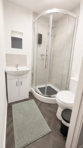 a bathroom with a shower and a toilet and a sink at Apex Rooms Salford - Free Parking in Manchester