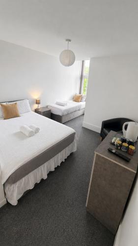 a white bedroom with a bed and a couch at Apex Rooms Salford - Free Parking in Manchester
