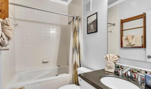 a bathroom with a tub and a sink and a toilet at Uptown Gatlinburg in Gatlinburg