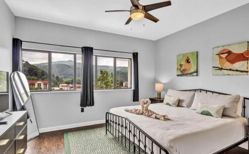 a bedroom with a bed with a ceiling fan and a window at Uptown Gatlinburg in Gatlinburg