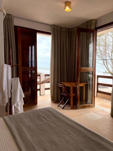 a bedroom with a bed and a desk with a view at Pousada Mahalo Preá Beach in Prea