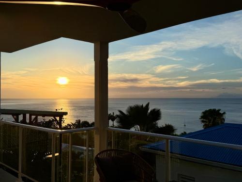 a view of the ocean from the balcony of a house at Espace Harmonie - Gîte Indigo Deshaies in Deshaies