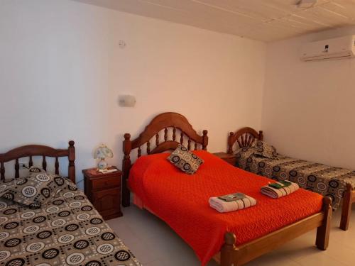 a bedroom with two beds and a red blanket at El Belichito in Belén