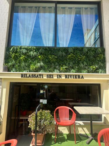 a restaurant with a table and chairs in front of a window at Hotel Sylva in Cattolica