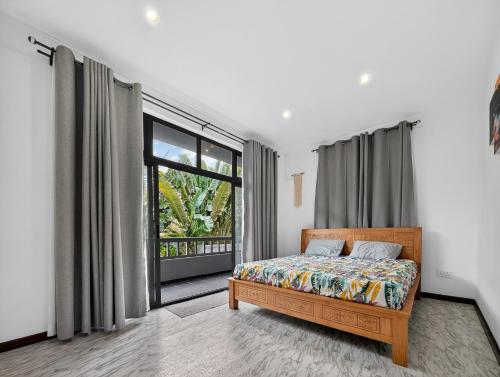 a bedroom with a bed and a large window at Spacious Pereybere 3BR Apartment in Grand-Baie